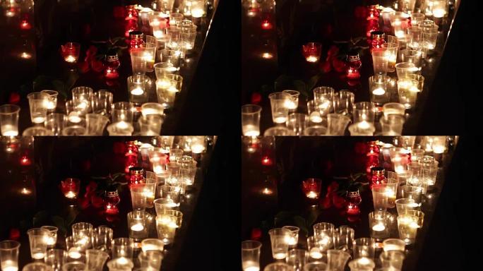 纪念碑上的鲜花和蜡烛，以纪念恐怖袭击受害者的受害者。恐怖袭击的后果，军事行动。人们哀悼和哀悼死者