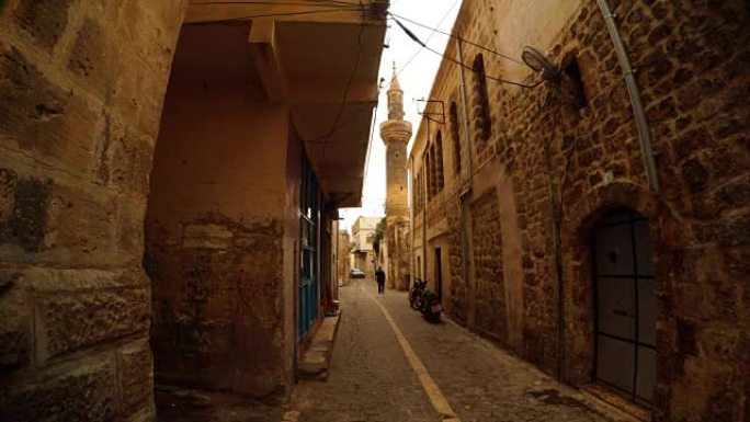 古老的清真寺塔楼在狭窄的古石街Urfa上方的尖塔