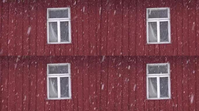 降雪时带窗户的红房子墙