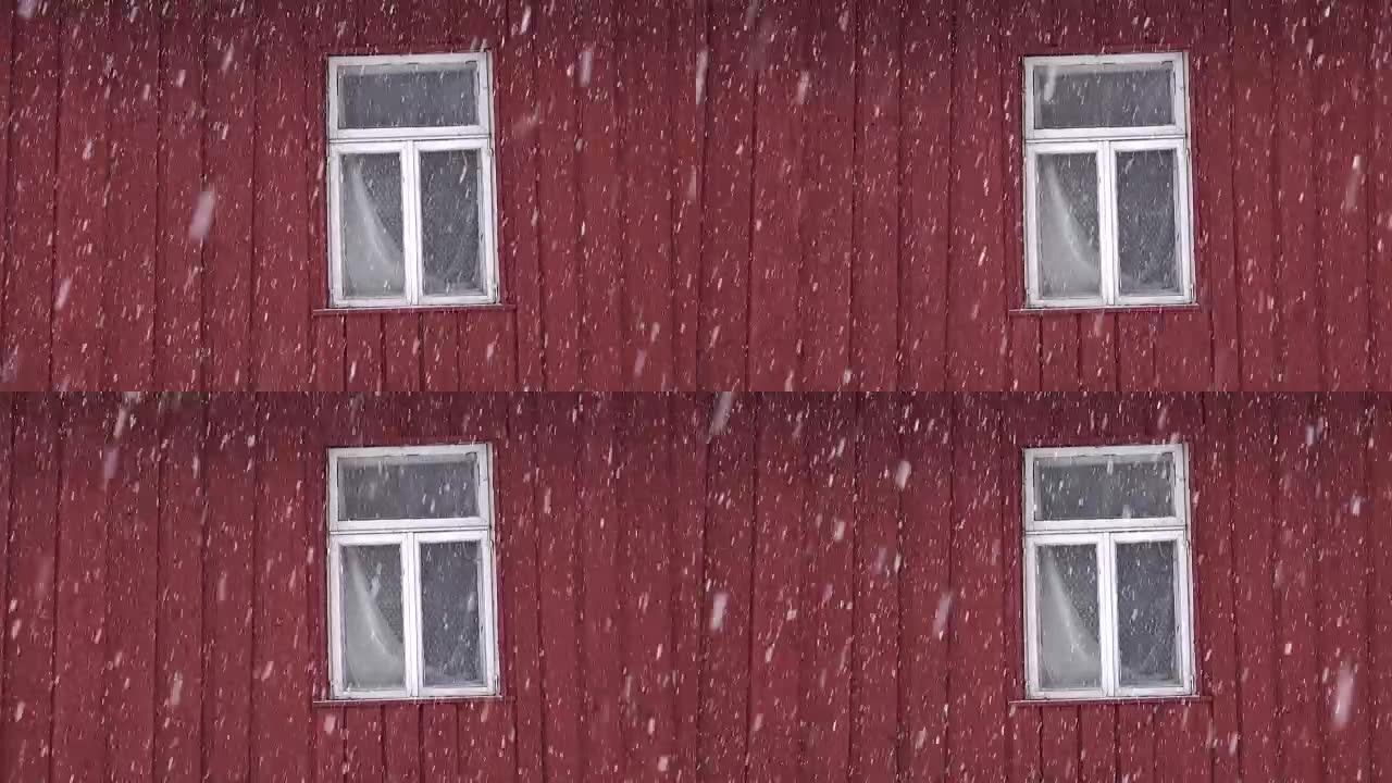 降雪时带窗户的红房子墙