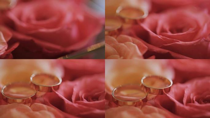 两枚金色新娘戒指躺在一束红玫瑰上