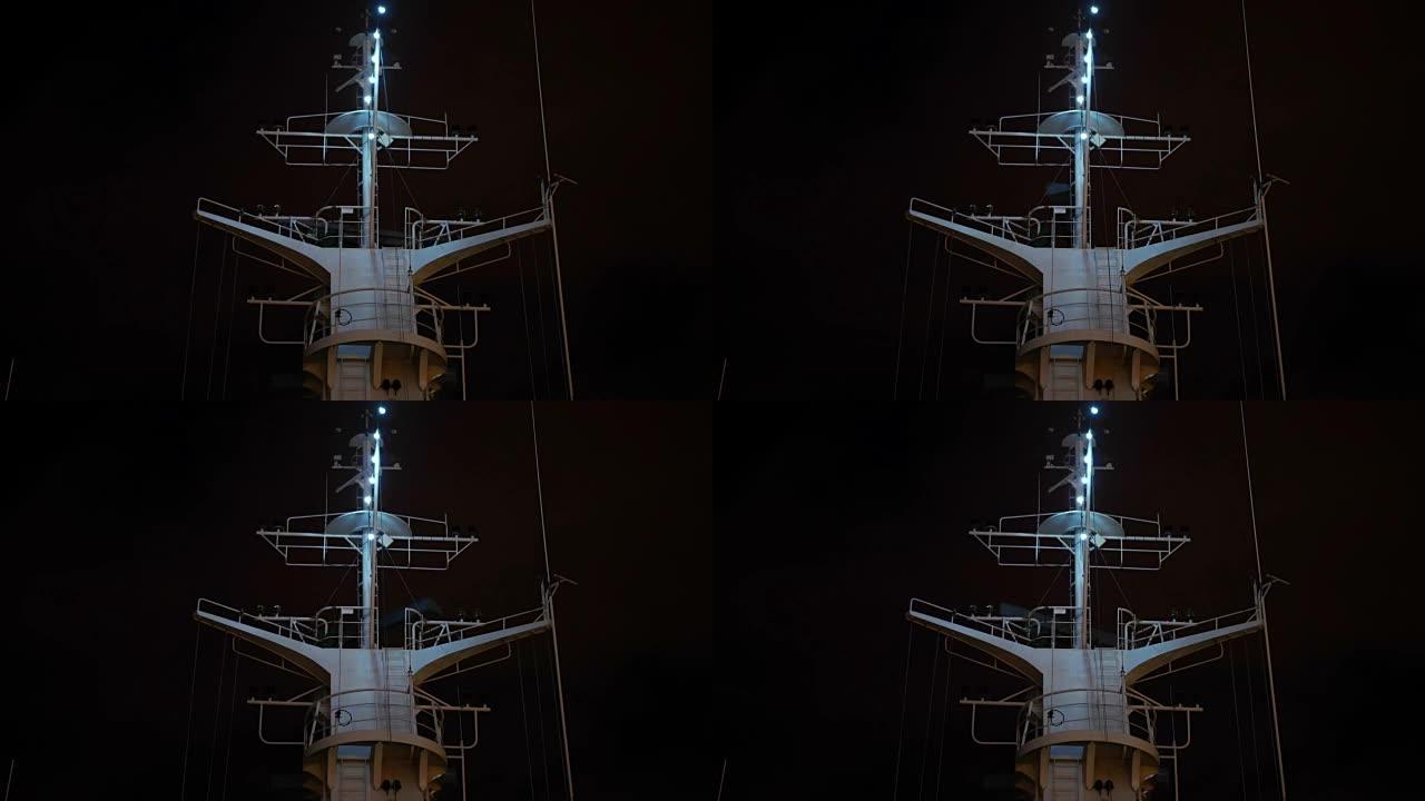 在白色游轮的最高点操作雷达被一组天线包围，夜晚