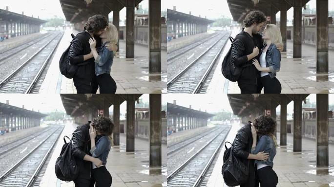 浪漫的情侣在雨天在分开前在火车站接吻和拥抱