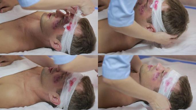 护士包扎头部绷带。一个受伤的男人脸上有瘀伤