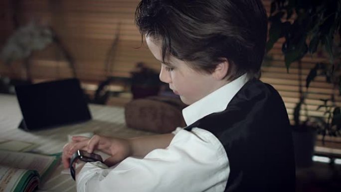 4k高科技拍摄的孩子做作业并检查他的智能手表