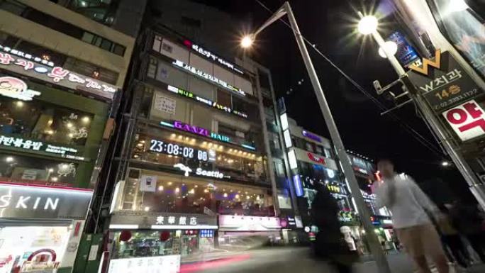 夜间街道的时光倒流，建筑物上有发光的横幅。韩国首尔