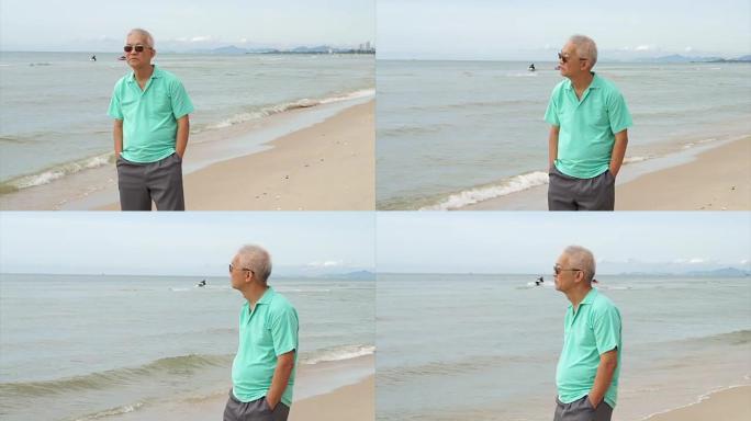 亚洲资深男子戴墨镜在海边思考人生规划