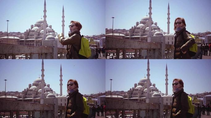 慢动作: 伊斯坦布尔的漂亮女孩看着港口和清真寺。一只大海鸥突然飞过，女孩真的很惊讶。旅行概念