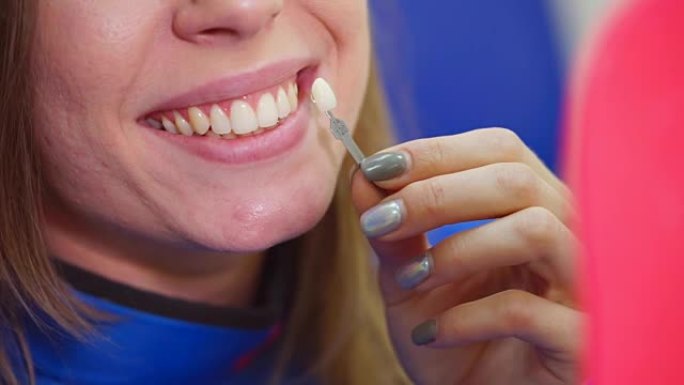 在牙科诊所看牙齿美白结果的女人