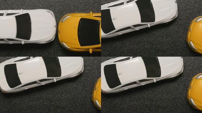 俯视图: 车祸-玩具模型车撞到白色玩具车的特写镜头 (慢动作)