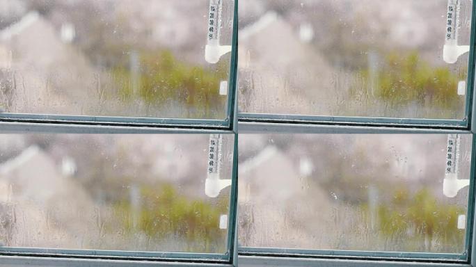 雨滴顺着窗户上的玻璃流下。显示窗外温度的温度计
