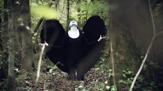 4k万圣节黑天使女人在森林里黑翅膀向天空喊叫