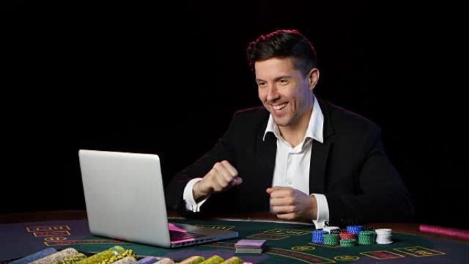 一个人在桌上玩在线扑克。近距离