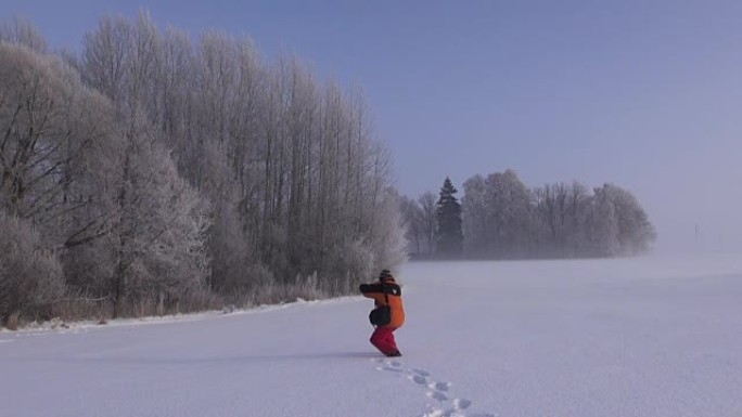 摄影师在积雪覆盖的田野中拍照