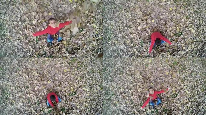 快乐男孩高高抛秋叶的俯视图。起重机慢动作镜头，120fps