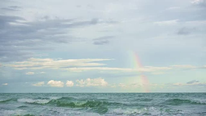 海上的小彩虹在日落和雨后的大海