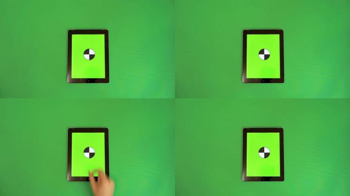 使用绿色屏幕的垂直数字平板电脑在绿色背景上缩小