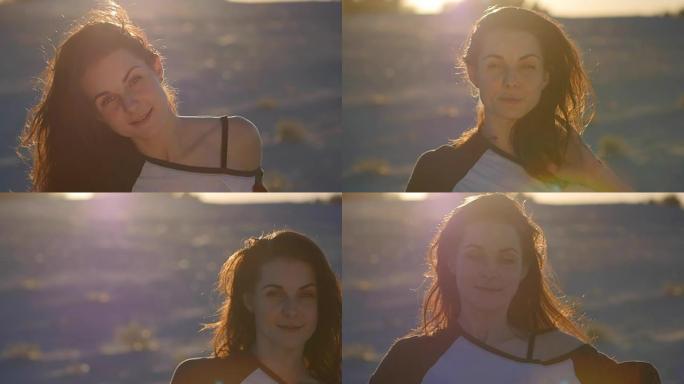 美丽的女人在日落时以慢动作在海上背景下摆姿势