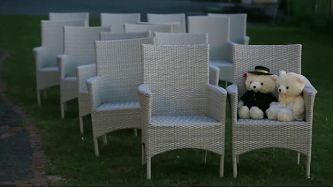 两只泰迪熊坐在椅子上。婚礼套装概念