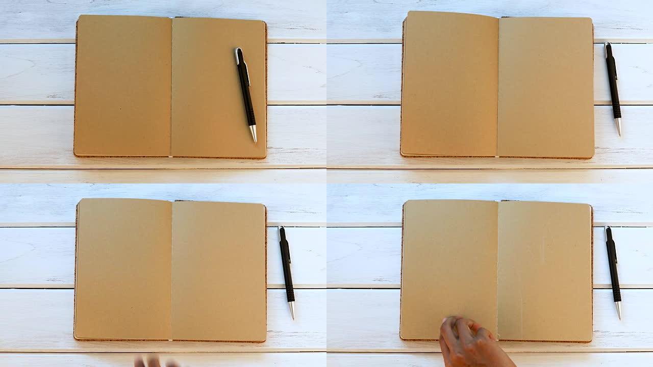 白色木制桌子上的男性手关闭日记本，俯视图和头顶镜头用于空白模板书模拟添加任何文本内容