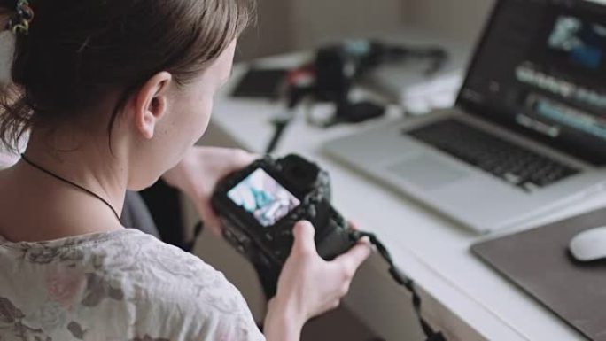 女摄影师在相机上查看照片