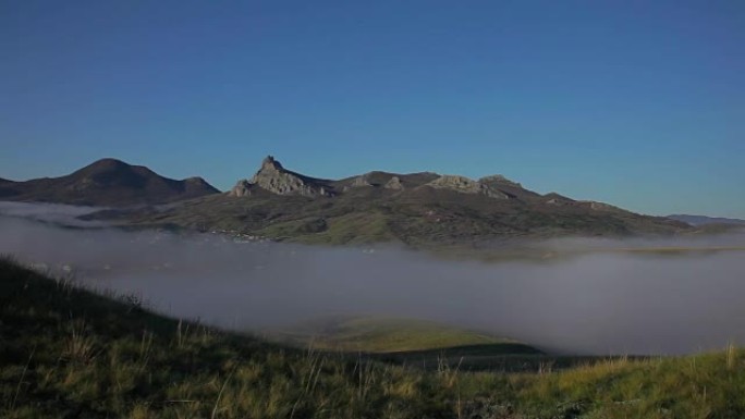 山的背景下的山谷中的雾驴