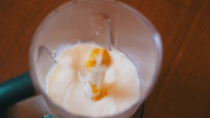 鸡蛋掉入家庭厨房的牛奶搅拌机中。慢动作