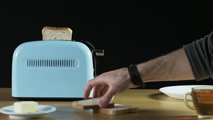 男子将两个面包放入电烤面包机中