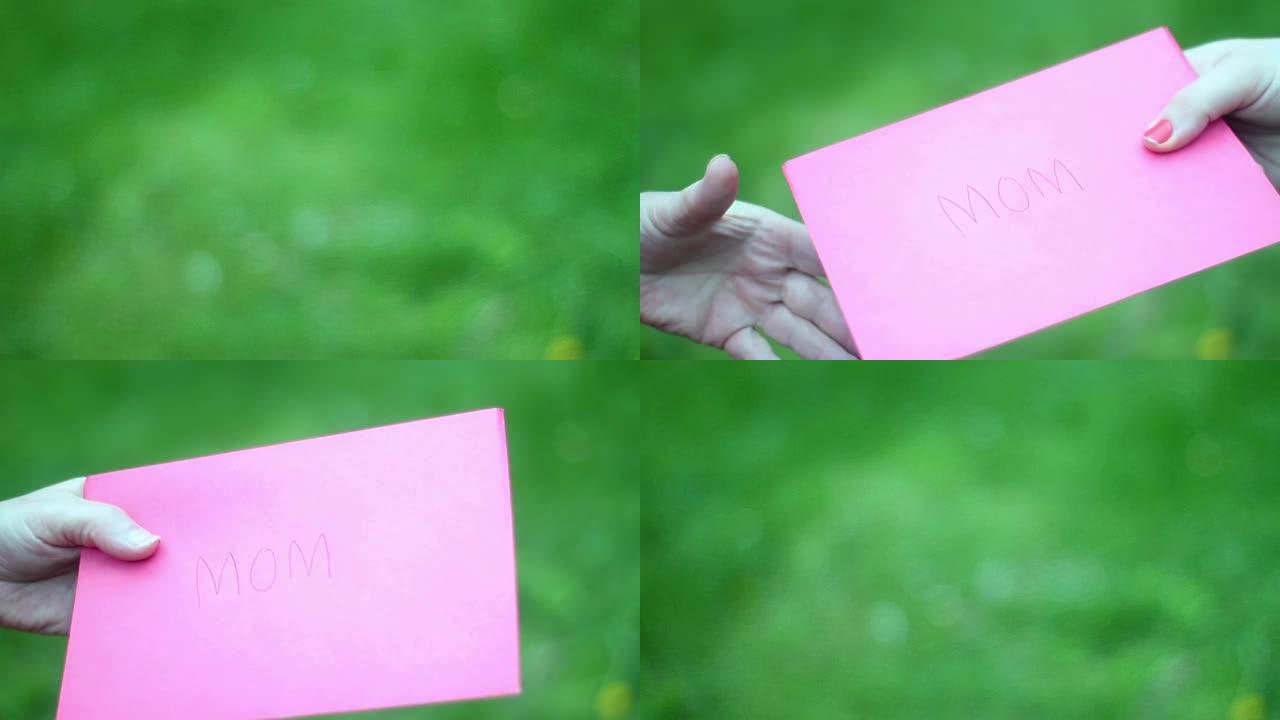 女儿用粉红色的爱心信封递给妈妈一张母亲节贺卡