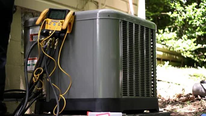 暖通空调技术人员对新运营的商业级空调进行制冷剂测试