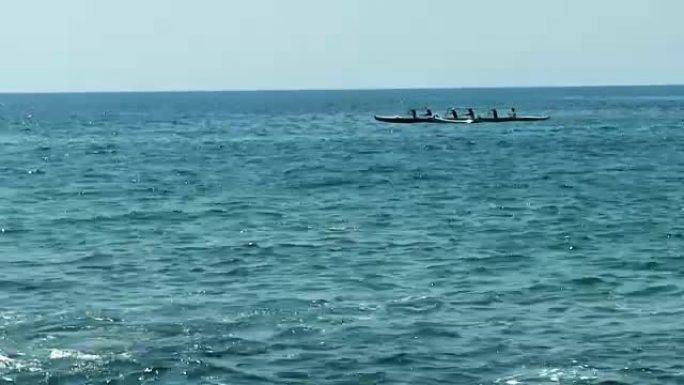 六人夏威夷独木舟在海洋中划桨