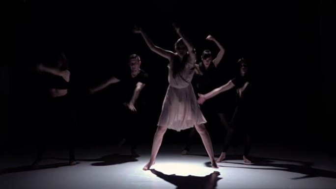 在黑色，阴影，慢动作上开始五位舞者的当代舞蹈