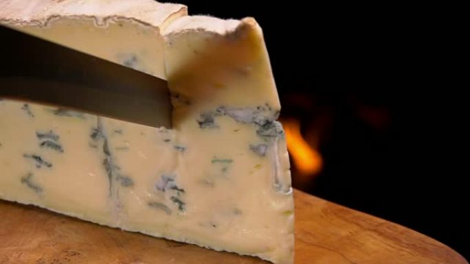 壁炉背景上切的蓝色奶酪