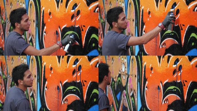 街头艺术家在普通的墙上画彩色涂鸦-现代艺术概念与城市人表演和准备活壁画与喷雾剂颜色喷雾-阳光明媚的下