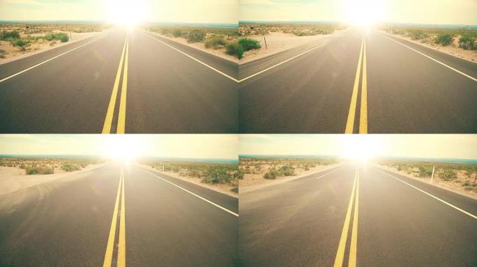 空旷的沙漠路中间朝着炎热的太阳耀斑