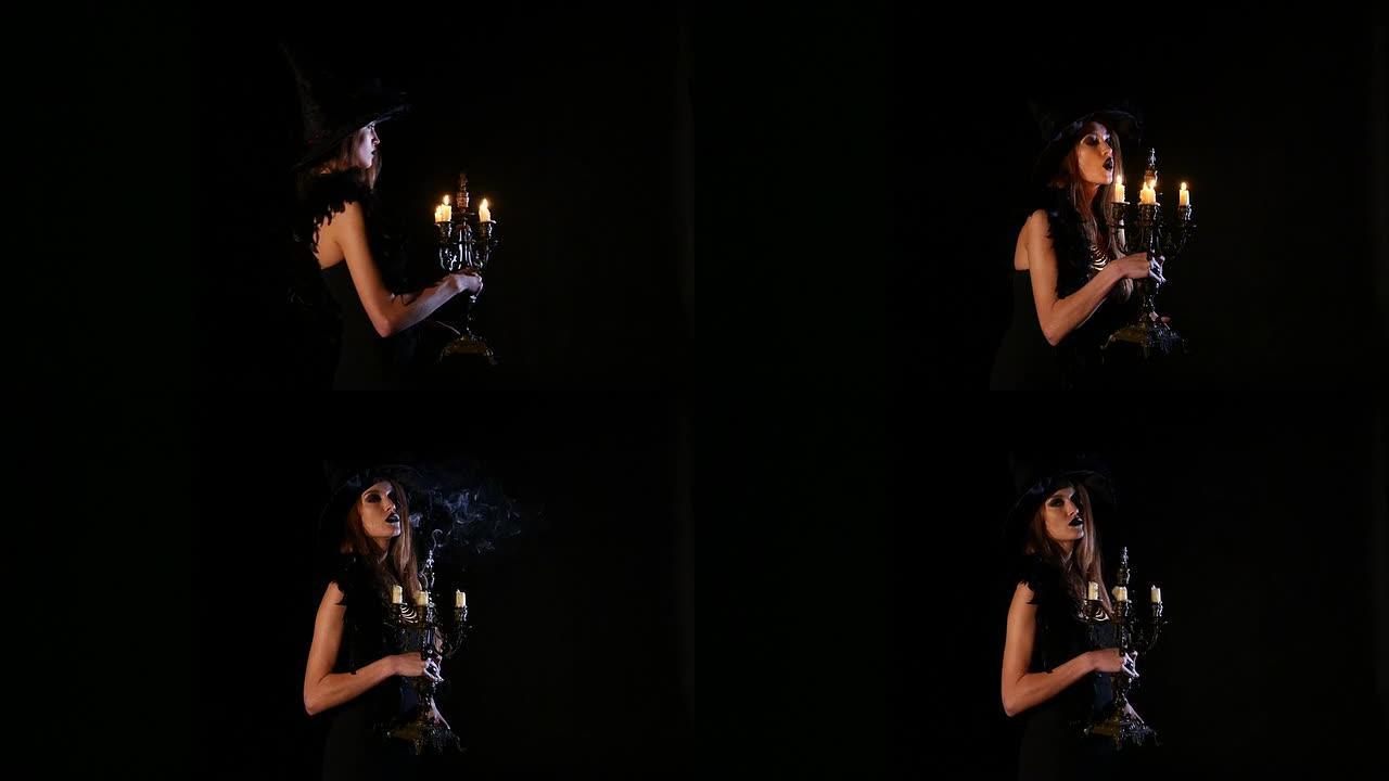 年轻性感的女巫吹灭黑色的蜡烛
