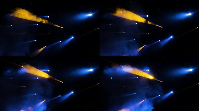 演出期间，聚光灯下的蓝黄灯光穿过剧院的烟雾。照明设备
