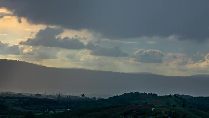 在日落的灯光下，黑暗的雨云在山上流逝