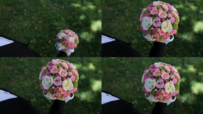 新郎举起手里的婚礼花束。美丽的婚礼鲜花花束