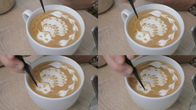 桌子上是一杯带泡沫的咖啡，男人在泡沫图案上画画