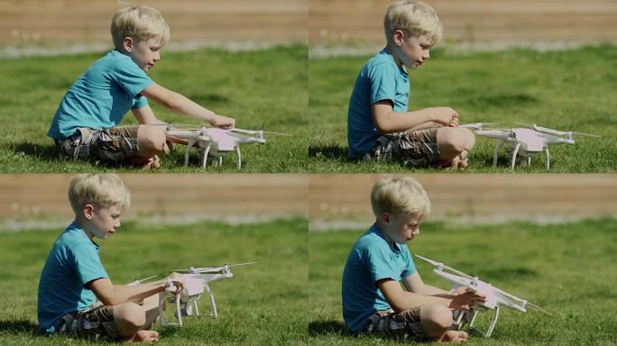 儿童在绿草的草坪上组装现代无人机。穿上螺旋桨