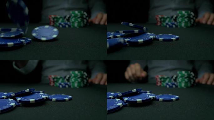 把蓝筹股扔进扑克里。蓝色和红色在反光黑色背景下玩扑克筹码。慢动作时在绿色毛毡牌桌上堆叠的扑克筹码的特