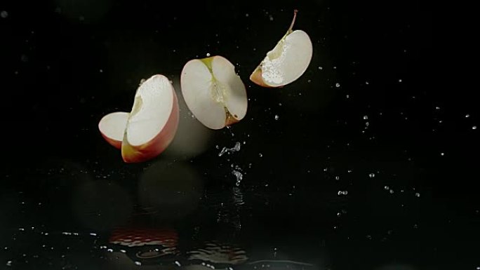 苹果，家蝇，黑色背景下落在水上的水果，慢动作4K