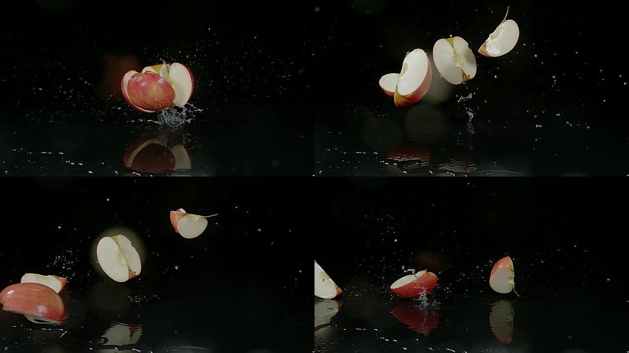苹果，家蝇，黑色背景下落在水上的水果，慢动作4K