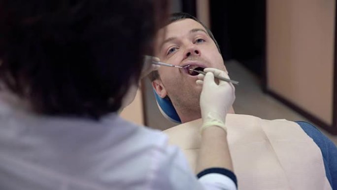 女牙医在诊所为男性患者制作程序，关闭