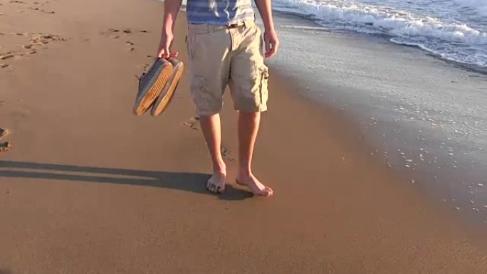 十几岁的男孩在日落时在加利福尼亚海滩和岩石上行走