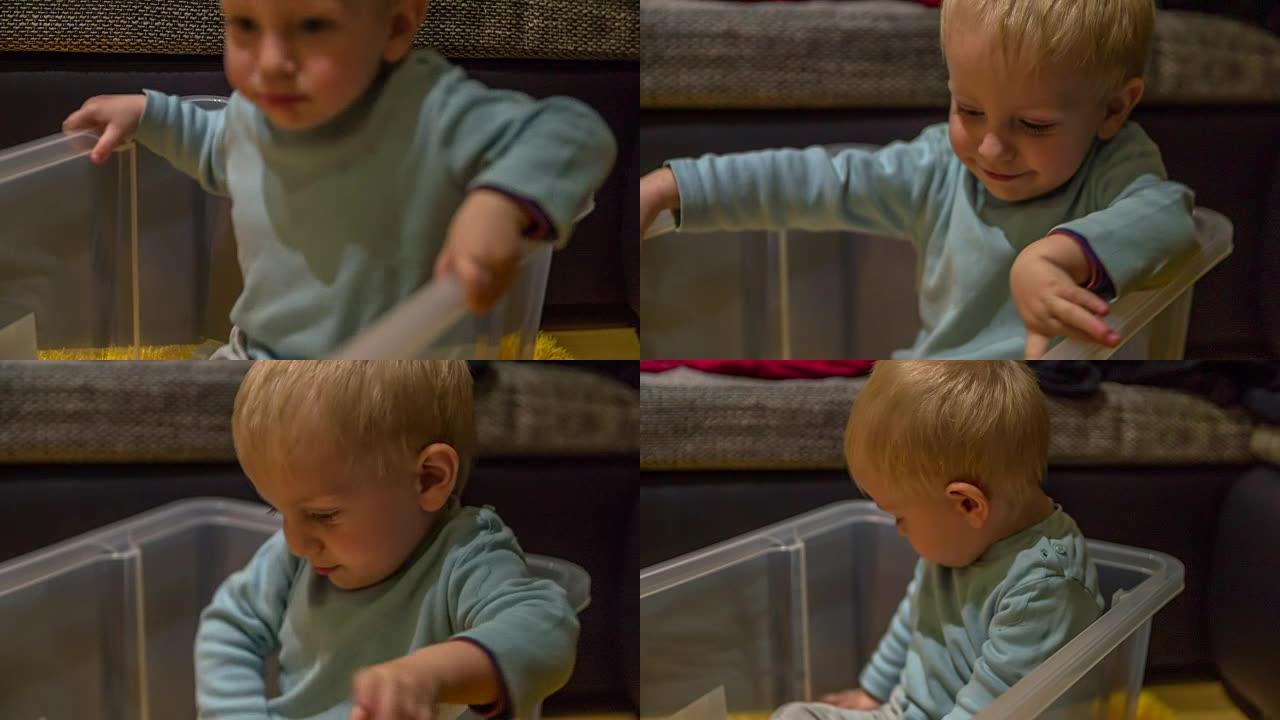 可爱的男孩为了玩而进入一个大塑料盒