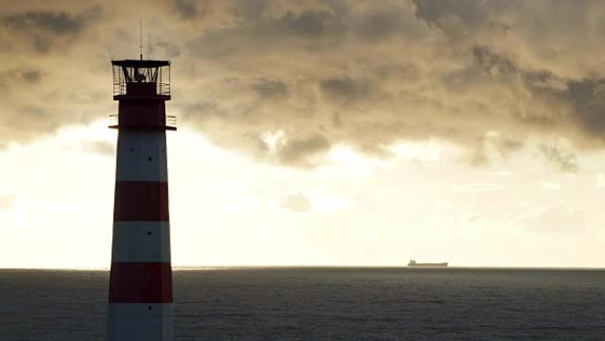 阴云密布下海上的延时灯塔，背景是船