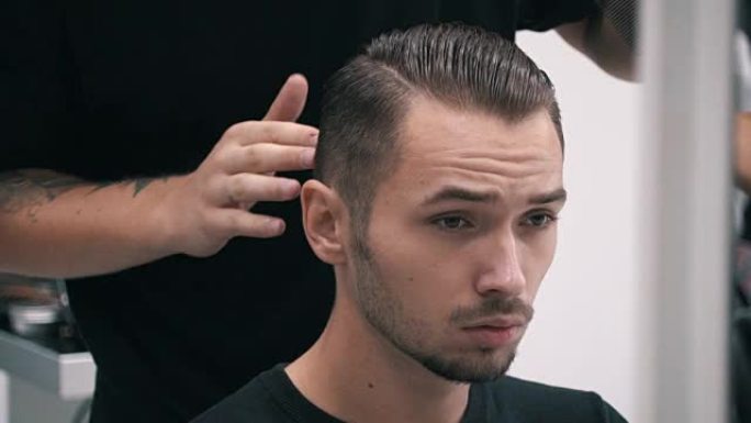 理发师在理发店理发后梳理客户的头发
