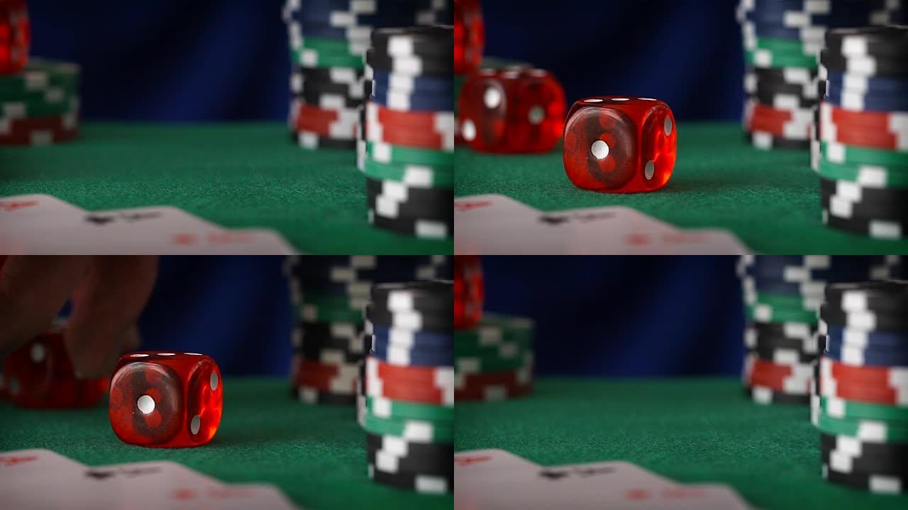 红色骰子在手指上滚动，赌场筹码，绿色毛毡上的卡